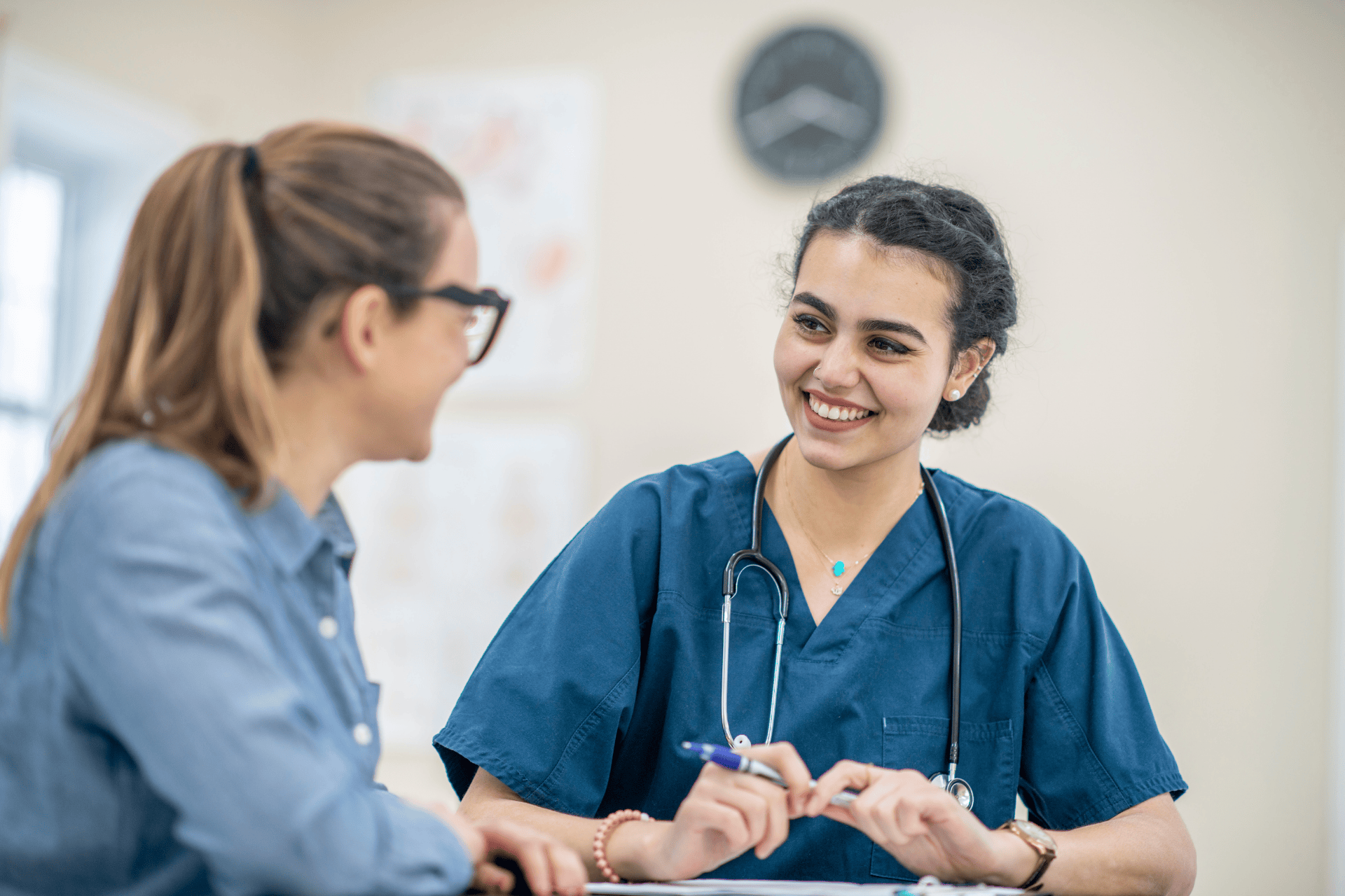 Smiling nurse talking with a patient during a consultation.