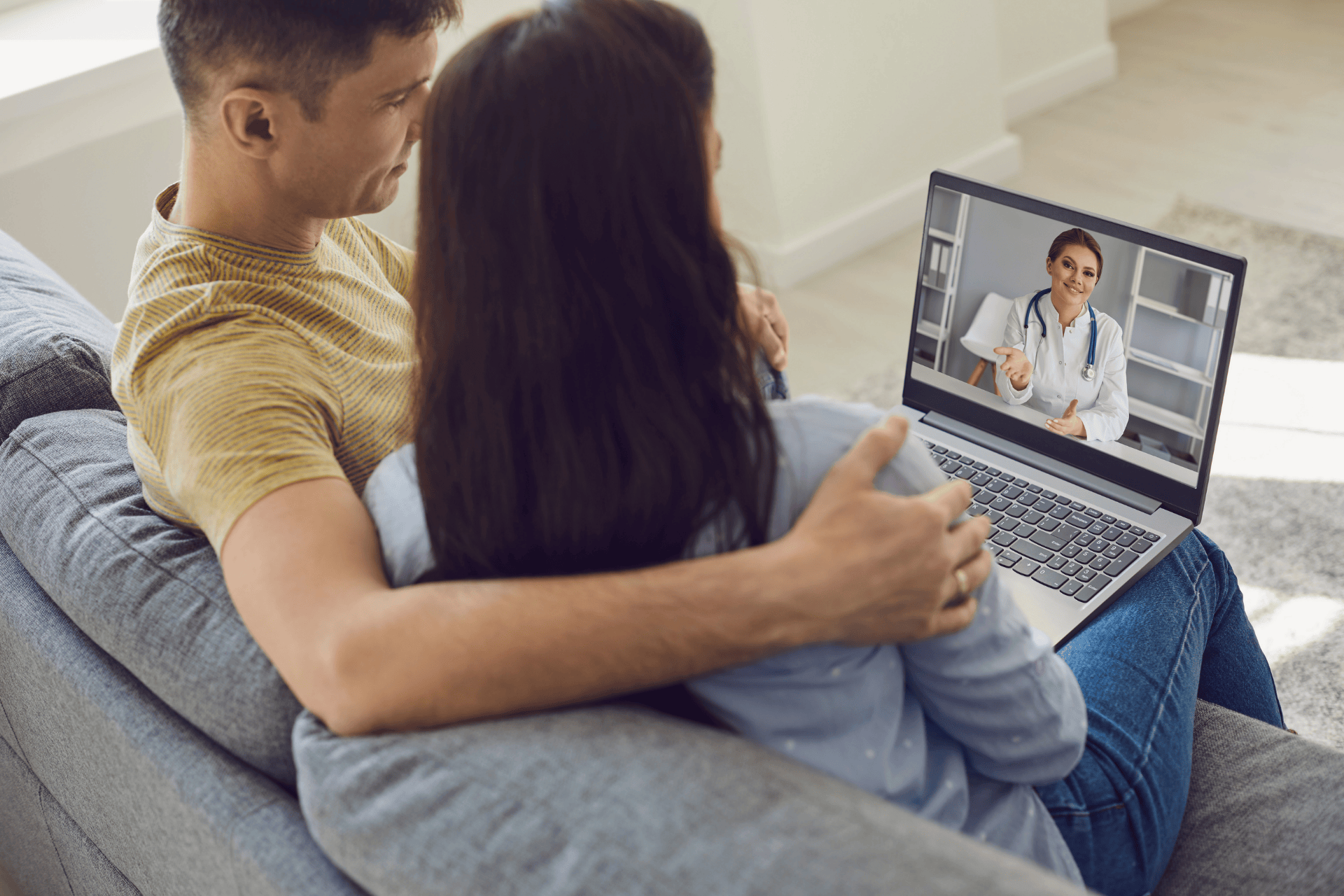 A Couple having an online video consultation with a doctor on a laptop.