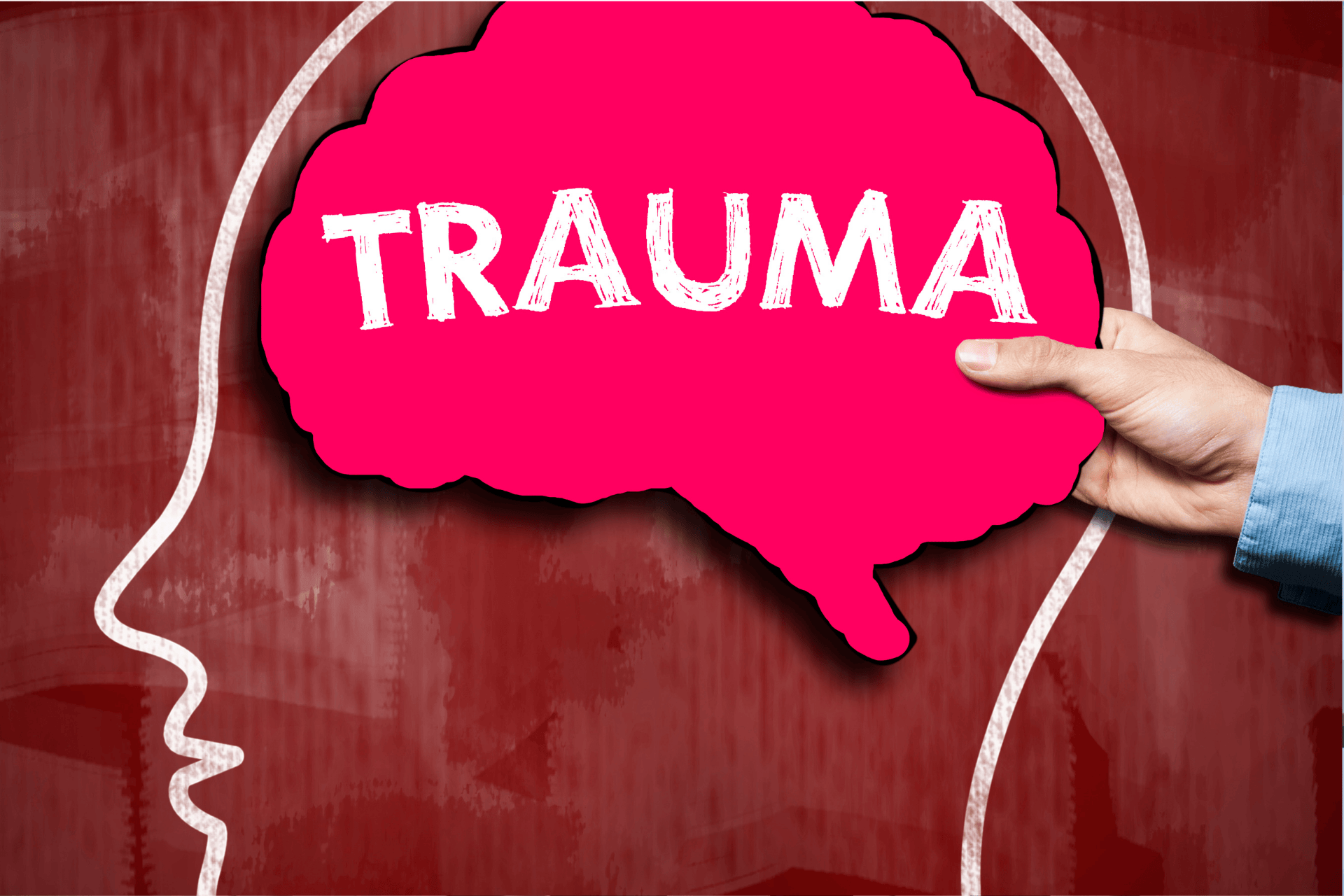 Illustration of a human head outline with the word trauma inside a brain shape.