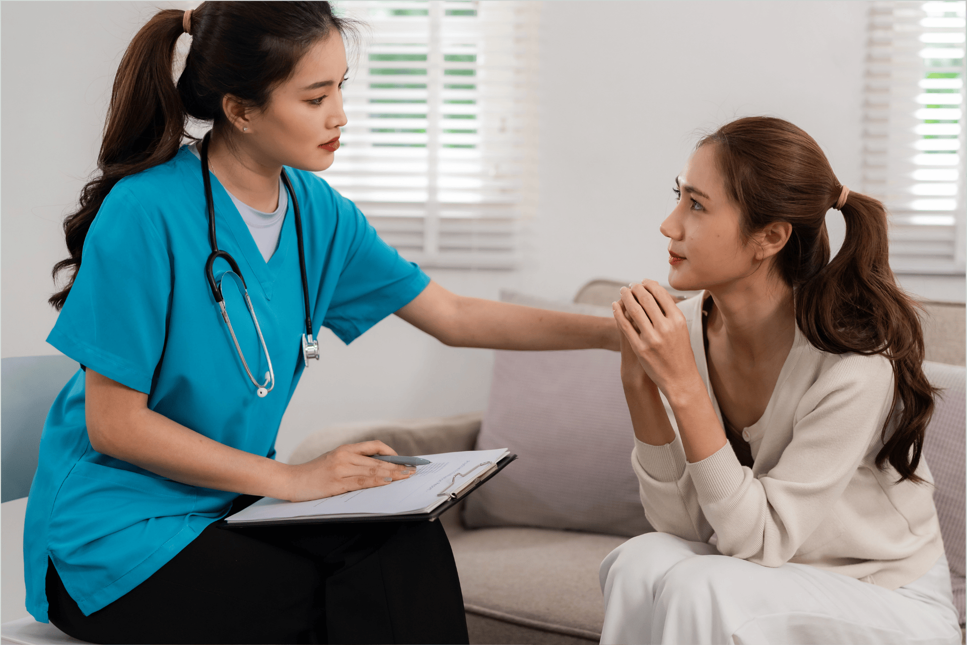 Healthcare worker comforting a woman during a counseling session.