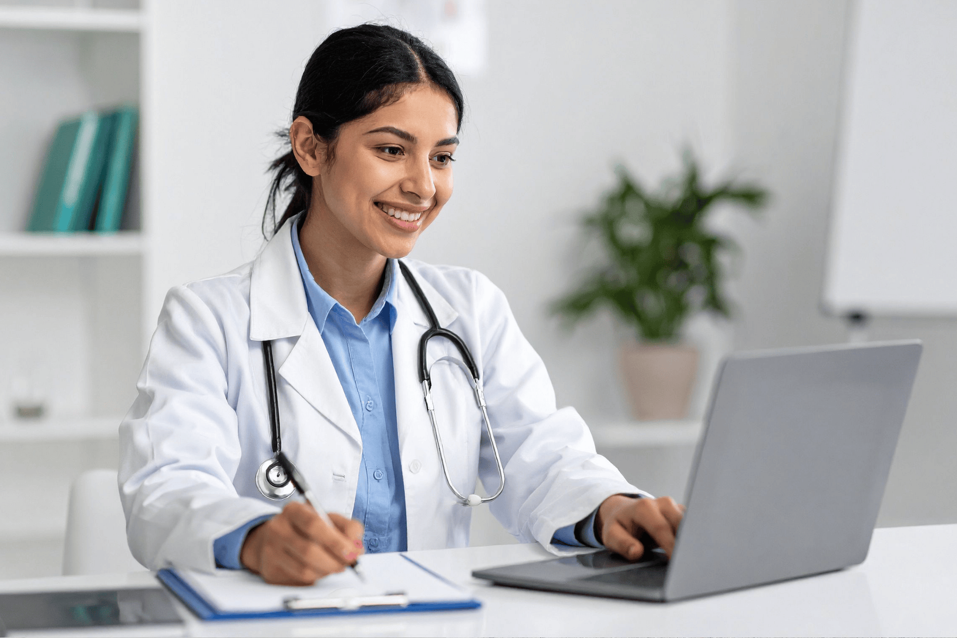 Smiling doctor using a laptop during an online consultation.