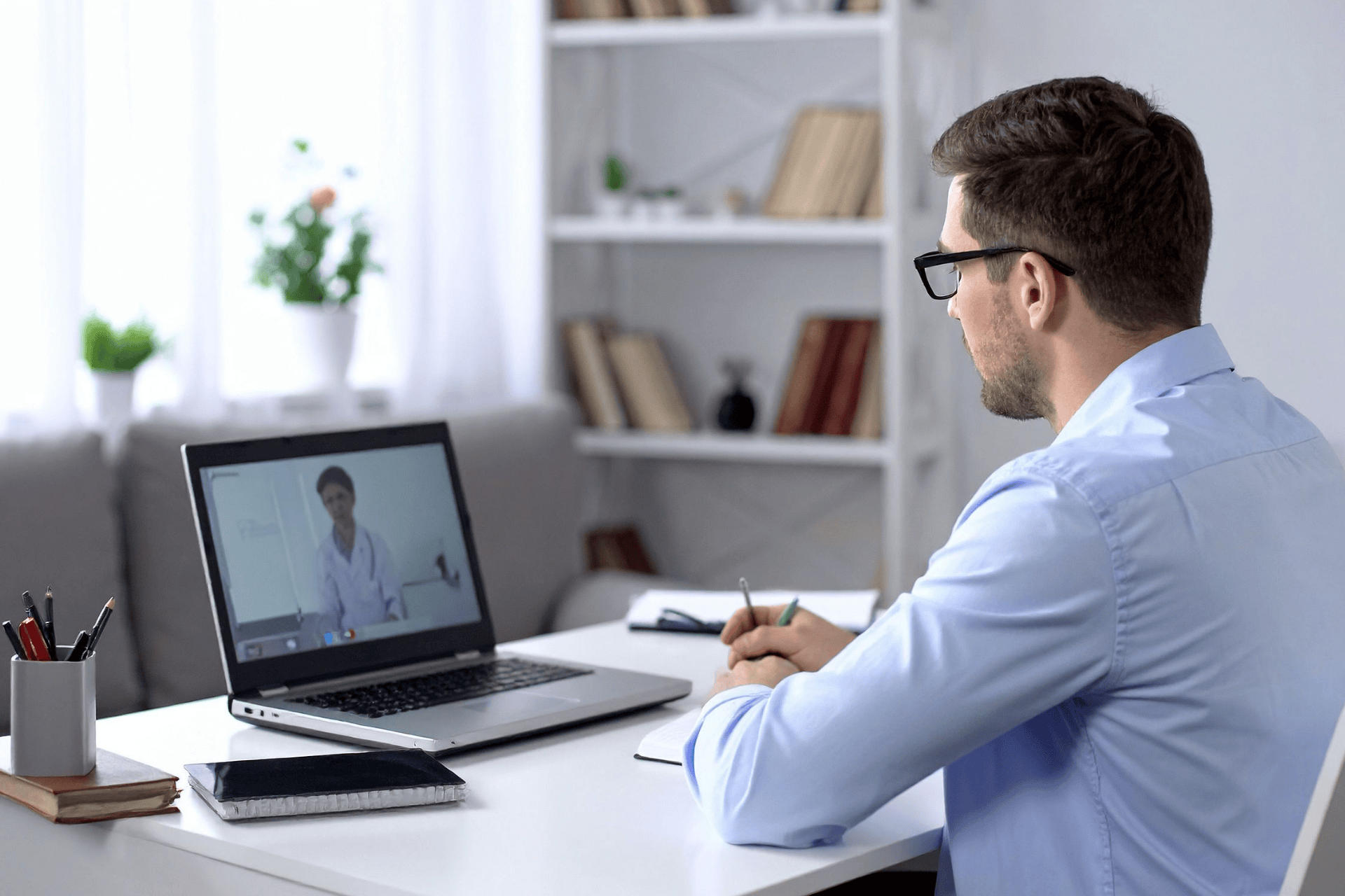 A Man having an online video consultation with a doctor on his laptop.