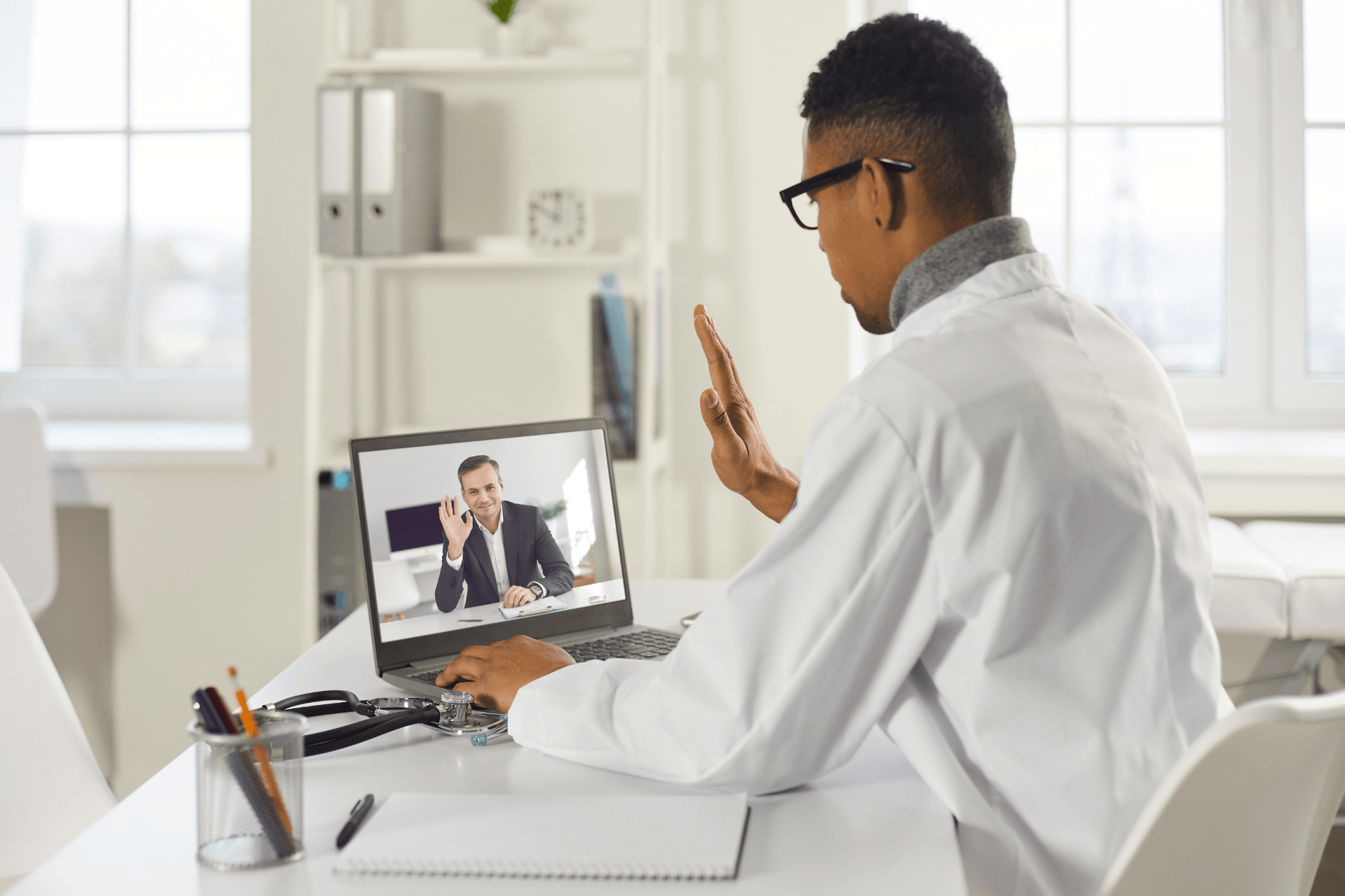 Doctor having an online video consultation with a patient on a laptop.