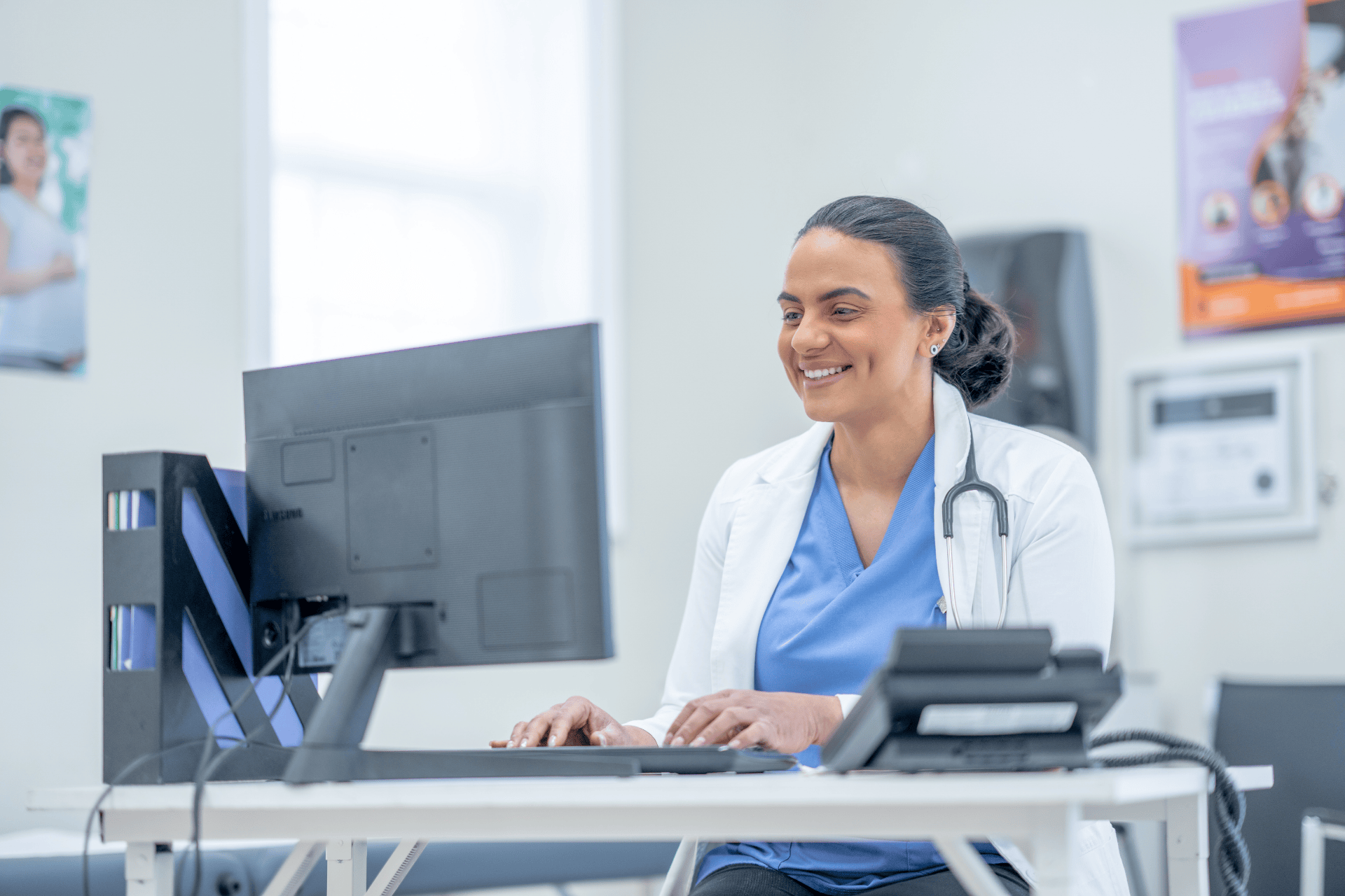 Smiling female doctor working on a computer in a medical office.