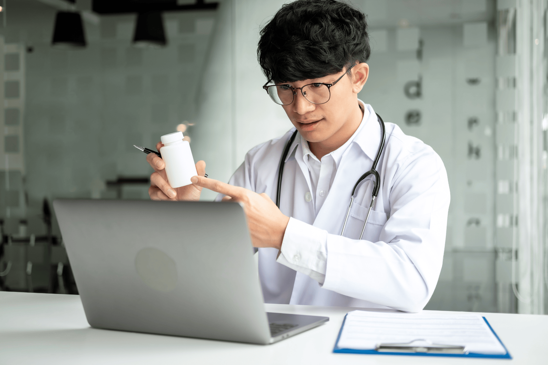 A doctor holding a pill bottle while explaining something during an online consultation.