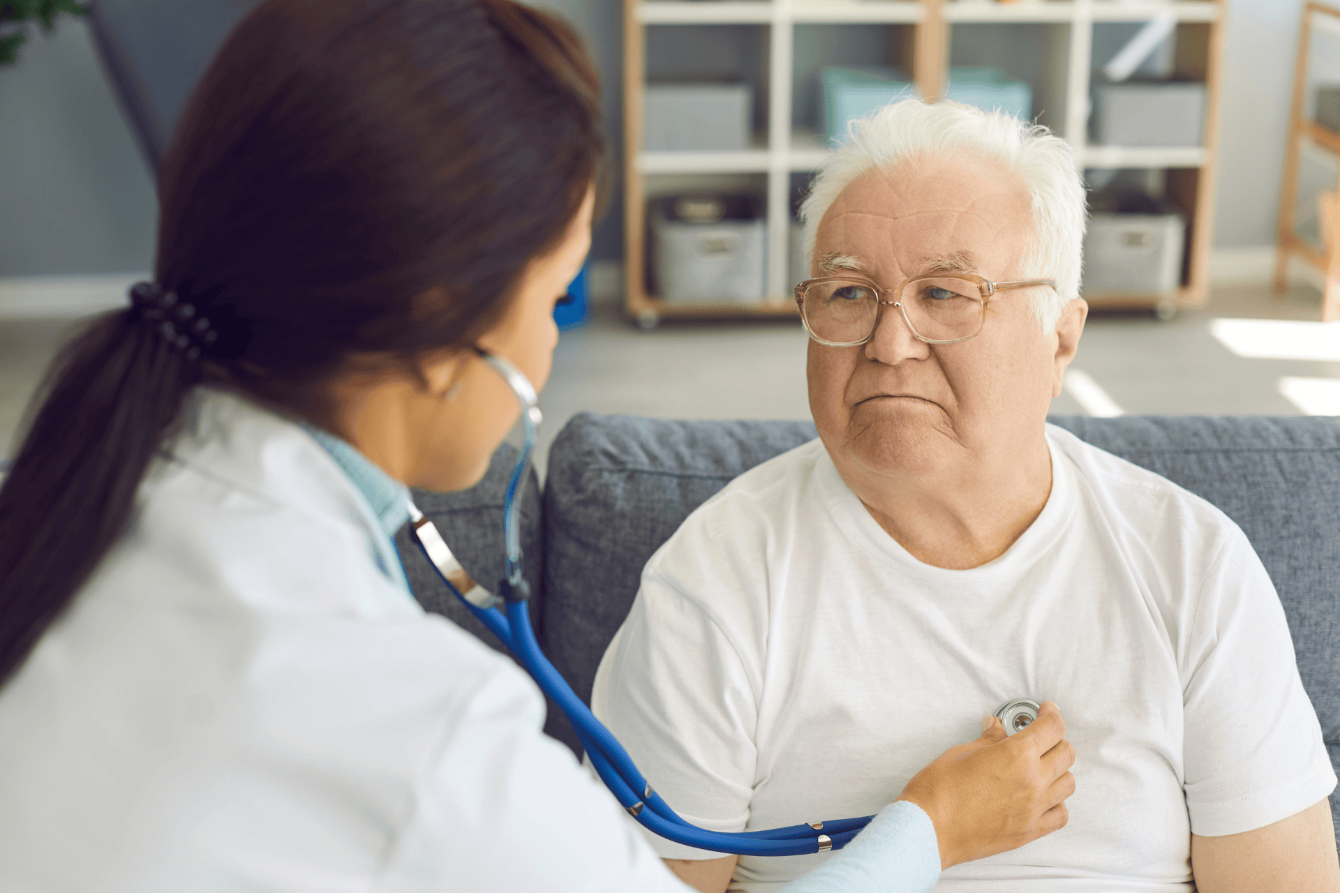 Healthcare provider using a stethoscope to listen to an older man’s chest.