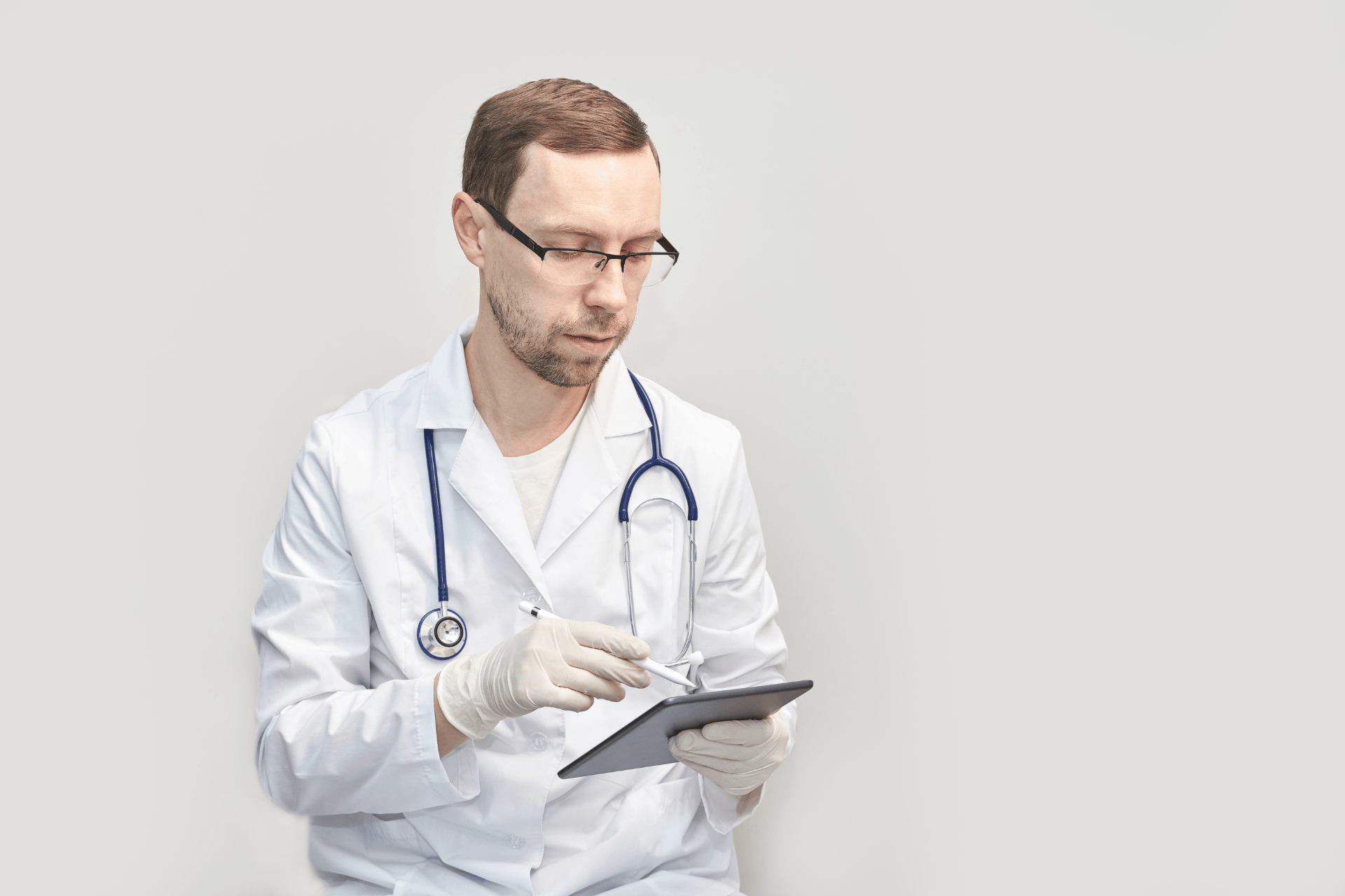 Doctor in a white coat using a digital tablet.