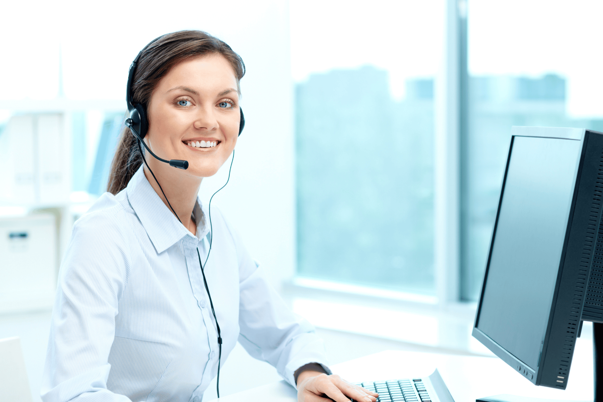 Smiling doctor wearing a headset while working at a computer.