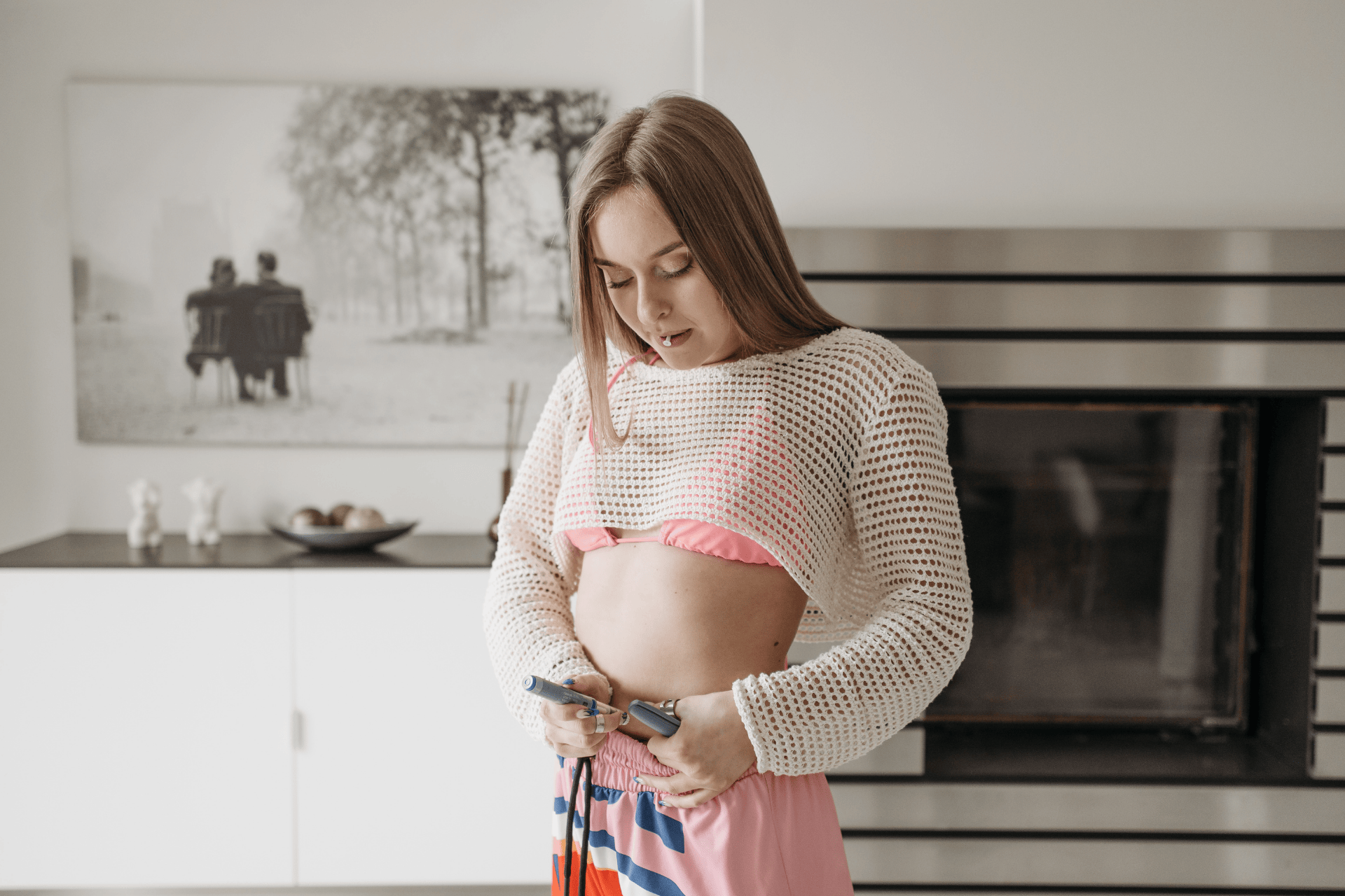 Woman giving herself an injection in the abdomen with an insulin pen at home.