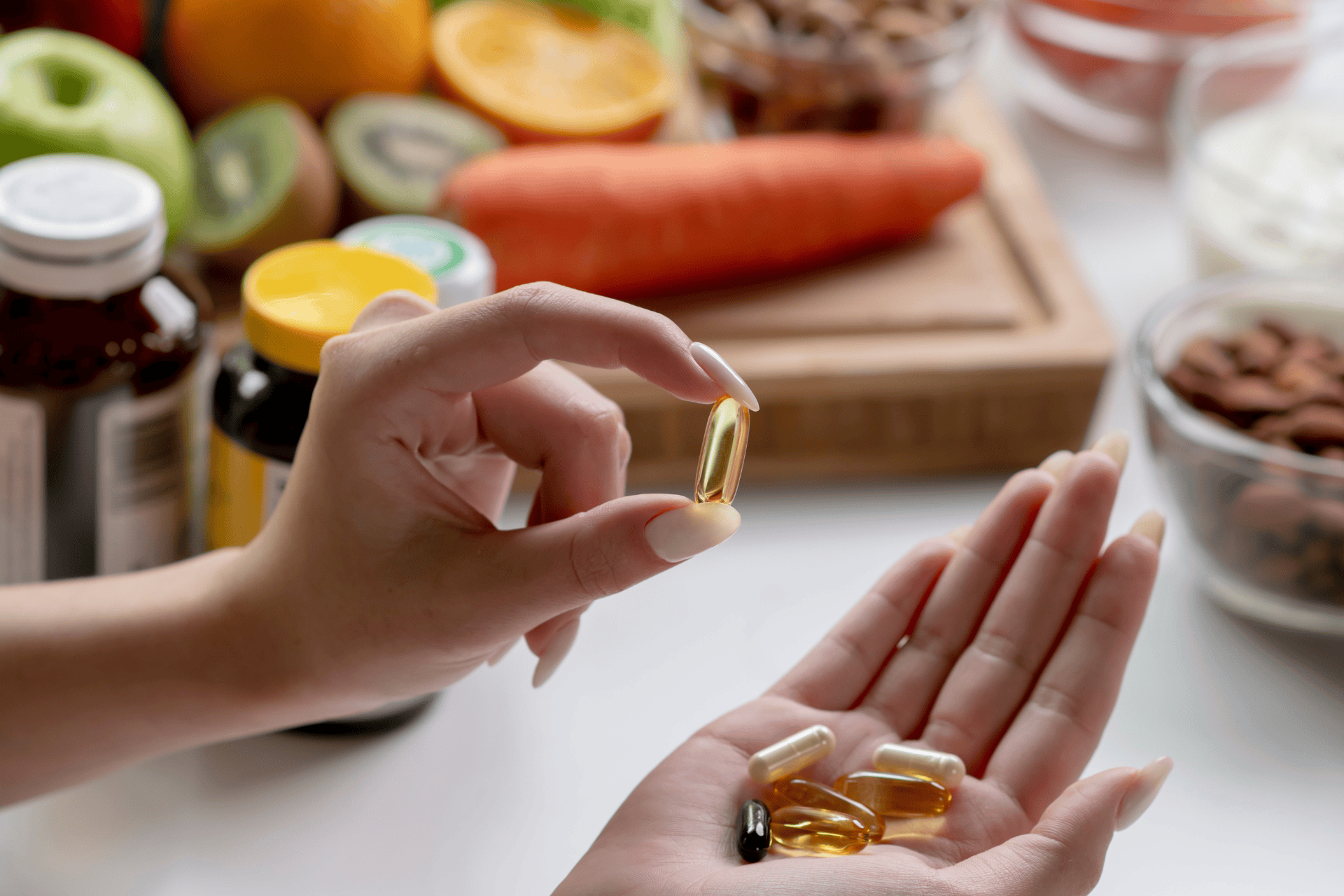 Hand holding weight-loss supplement capsules with fruits and bottles in the background.