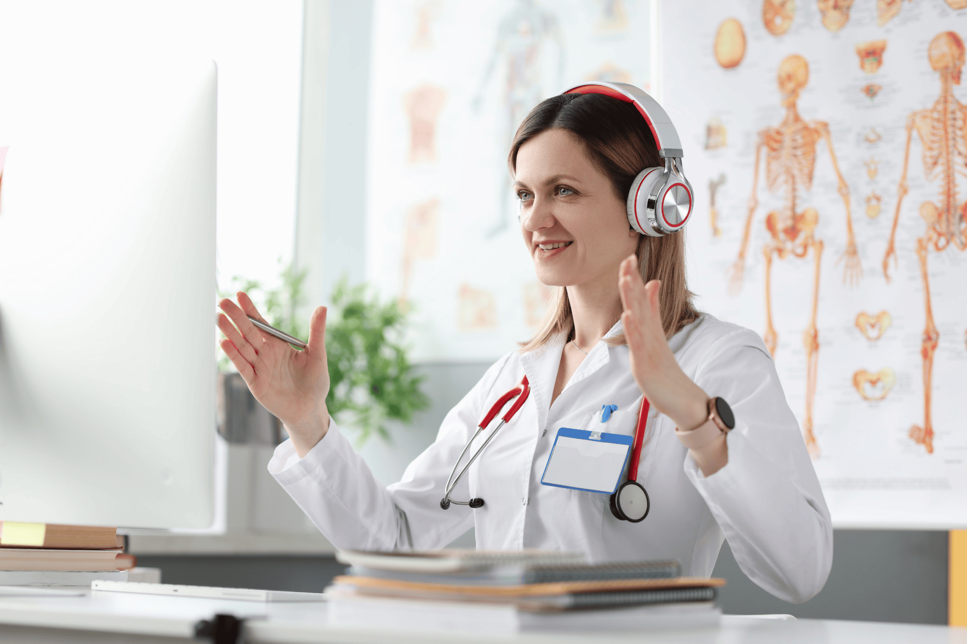 Female doctor wearing headphones gestures while speaking during an online consultation.