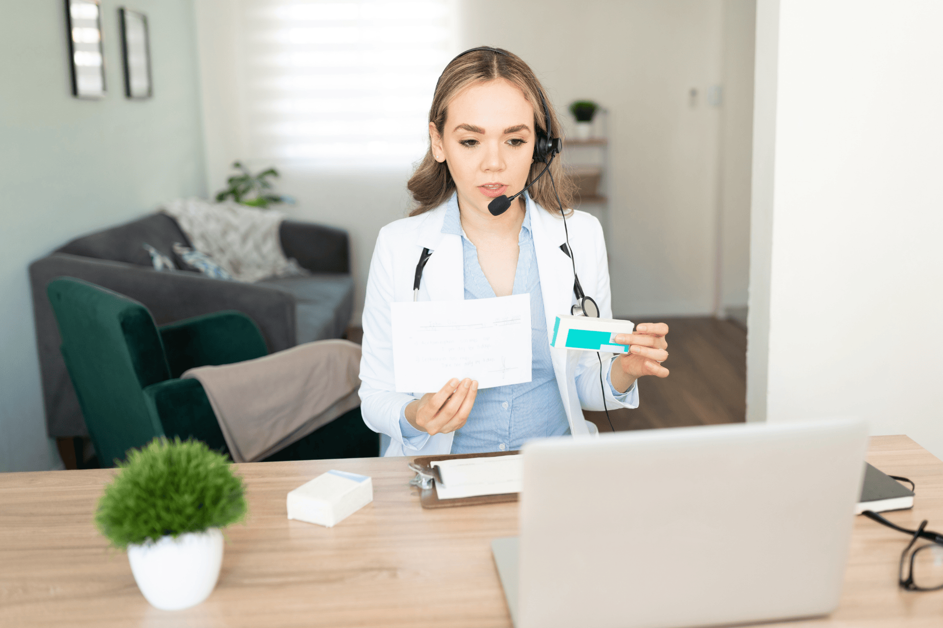 Doctor with a headset showing a prescription and medication during an online consultation.