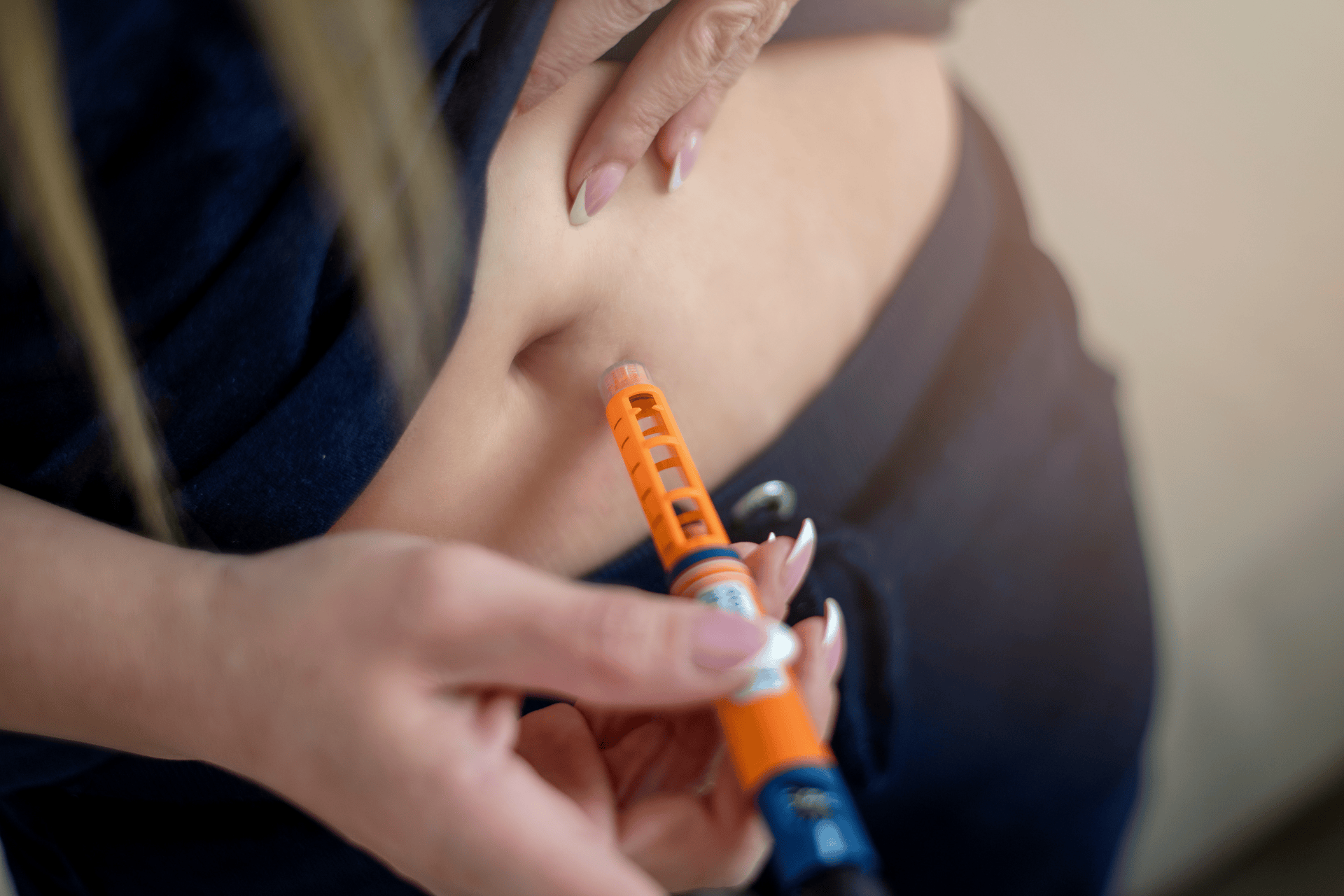 Person injecting medication into their abdomen with an injection pen.