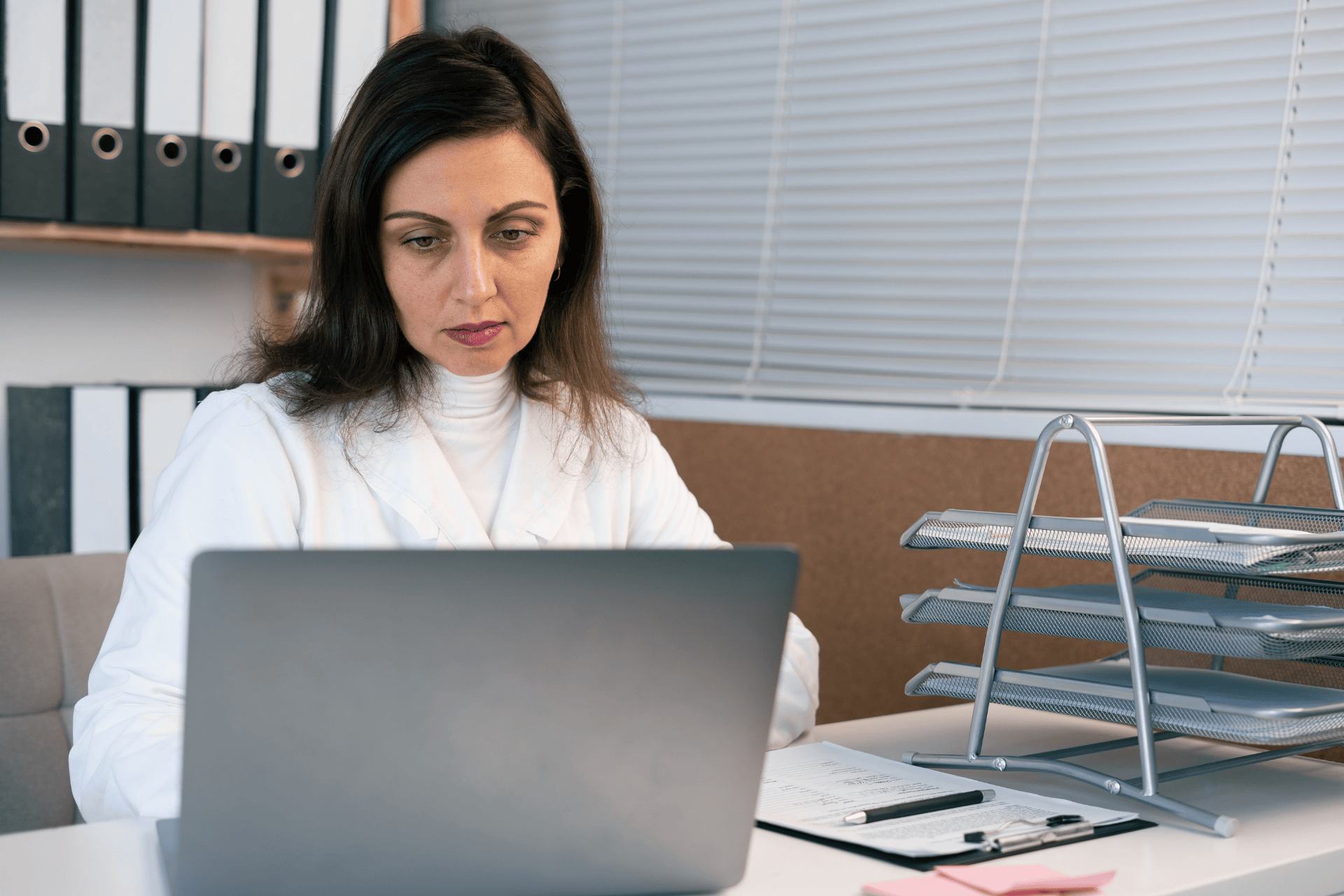Female doctor working on a laptop in an office.