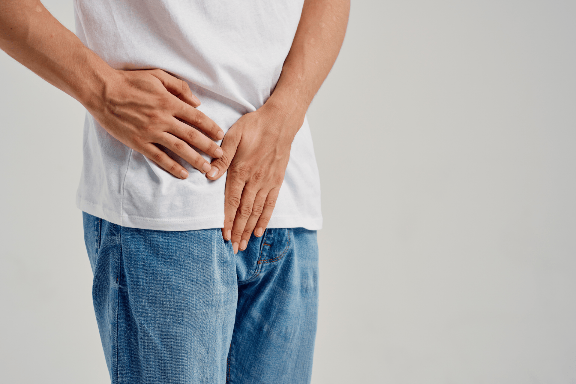 Man holding his lower abdomen and groin area, suggesting erectile dysfunction–related discomfort.