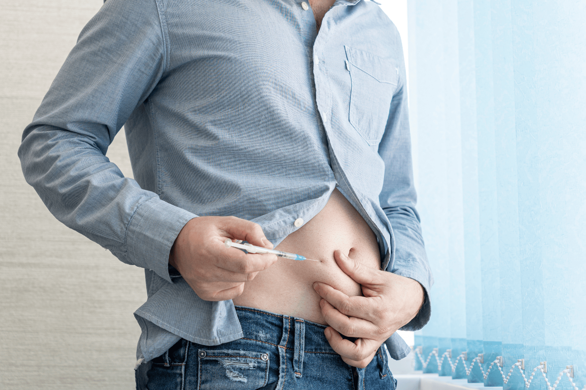 A man injecting insulin into his abdomen.