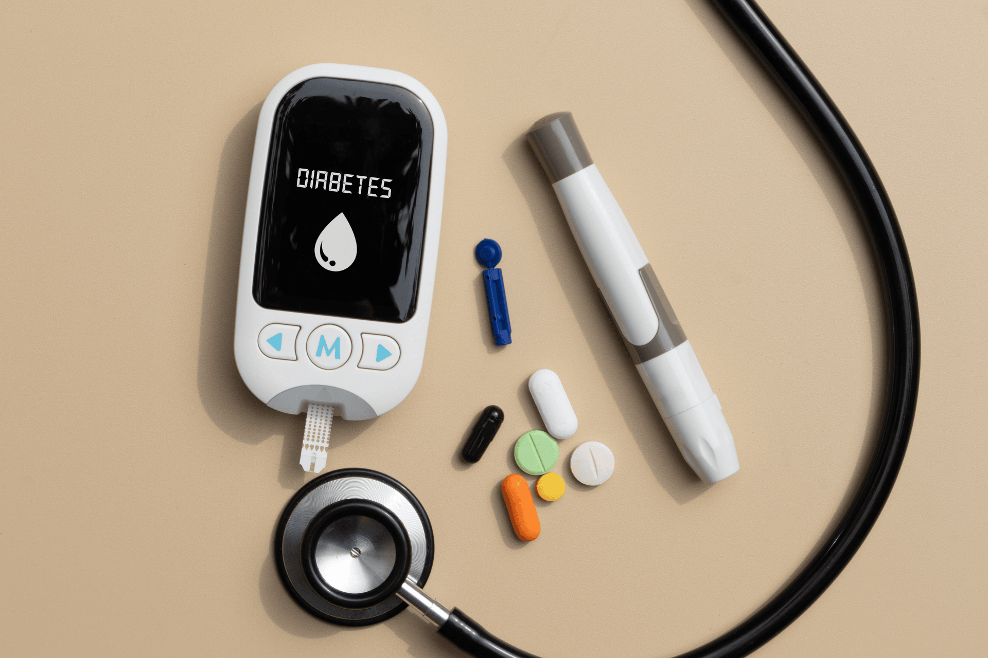 A blood glucose meter, lancing device, insulin pen, pills, and stethoscope representing diabetes care.