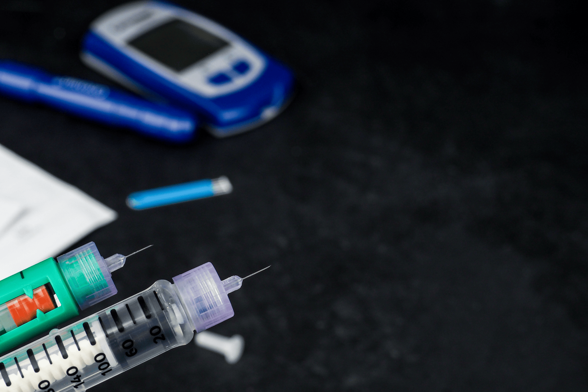 Insulin syringes and a glucose meter used for blood sugar monitoring and diabetes care.