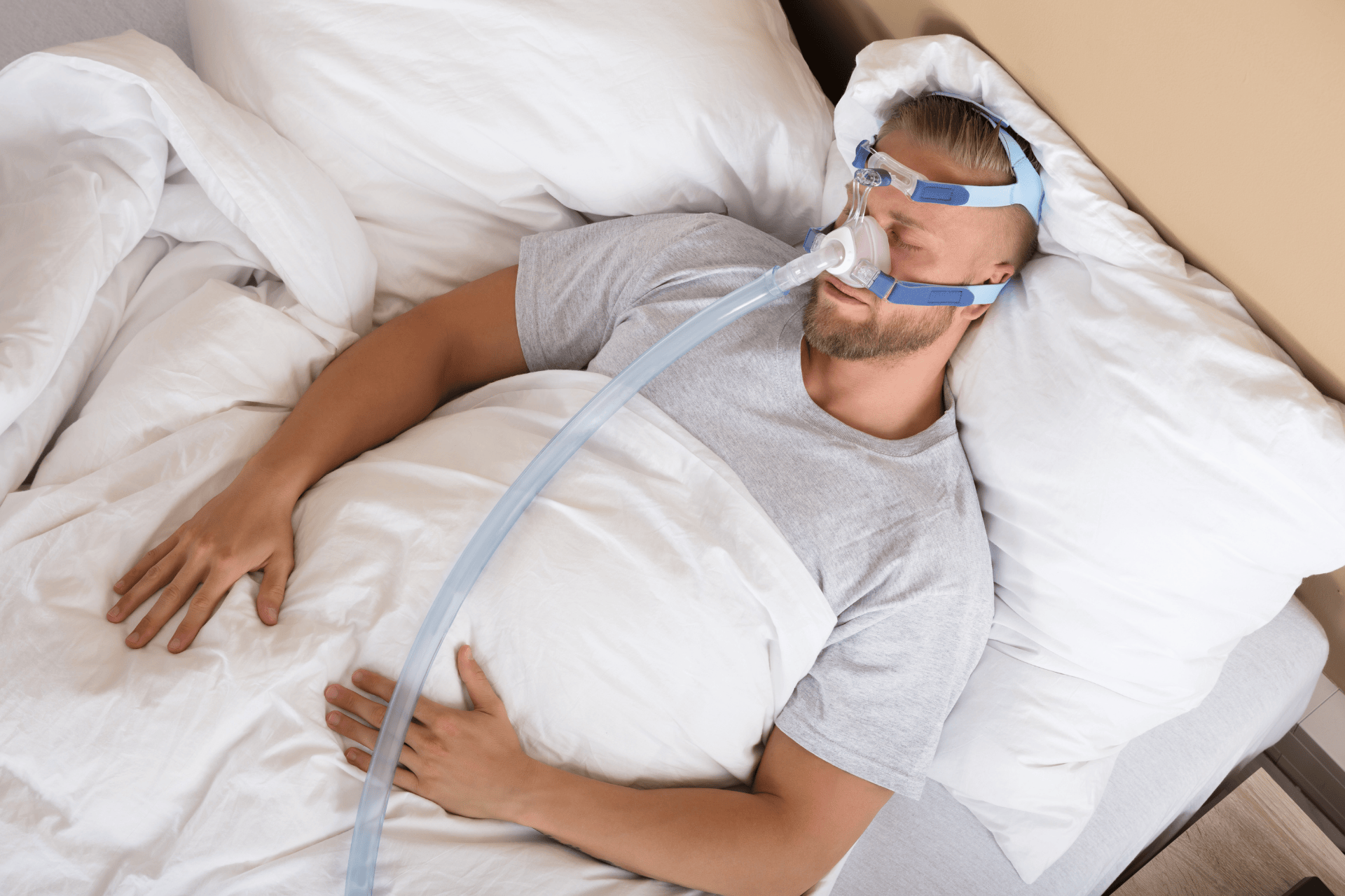 Man sleeping with a CPAP mask for sleep apnea therapy.