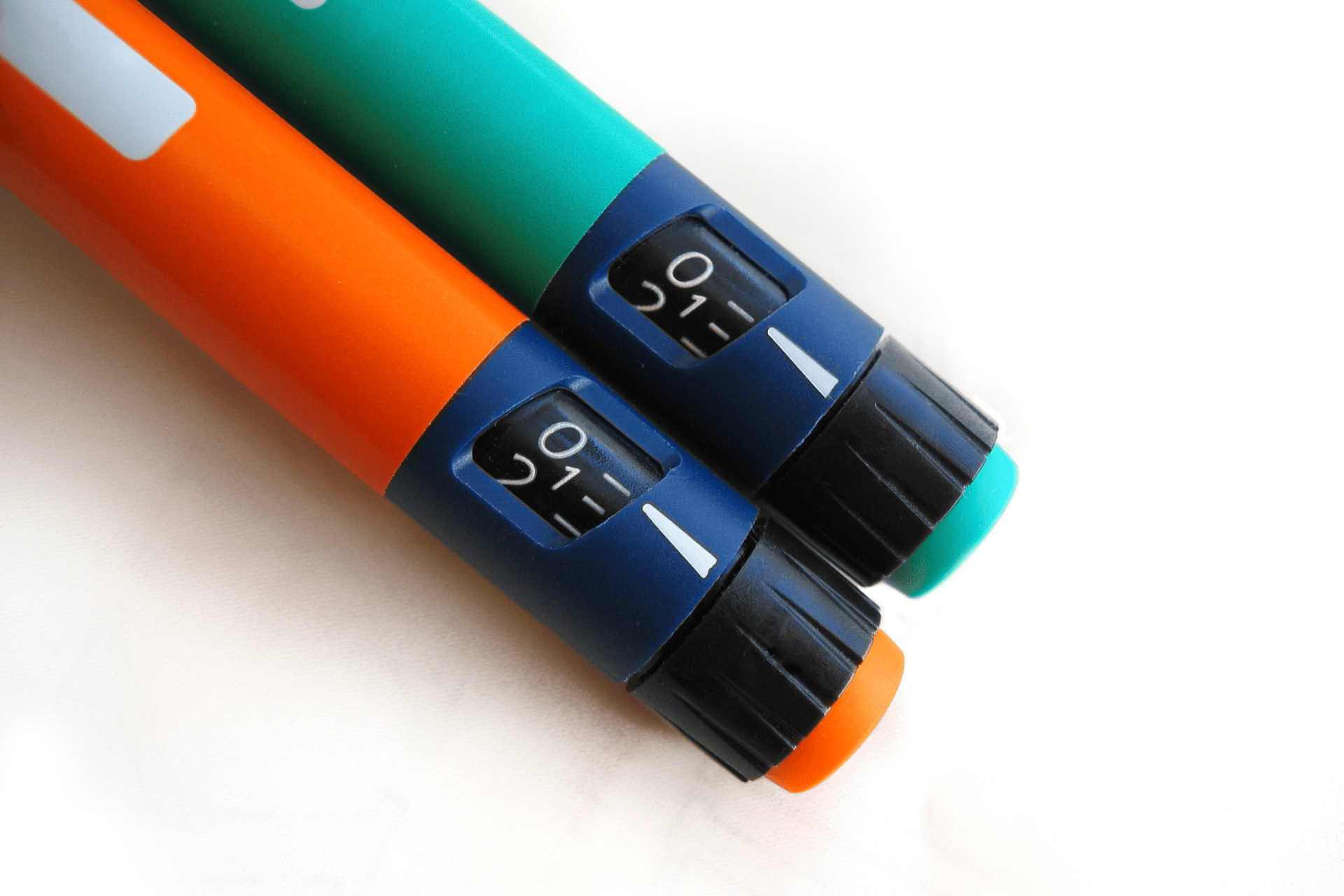 Close-up of insulin pens with adjustable dosage dials.