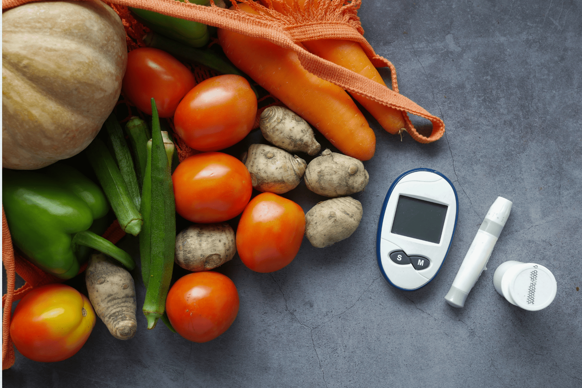 Fresh vegetables with a glucose meter and test kit representing healthy eating for diabetes.
