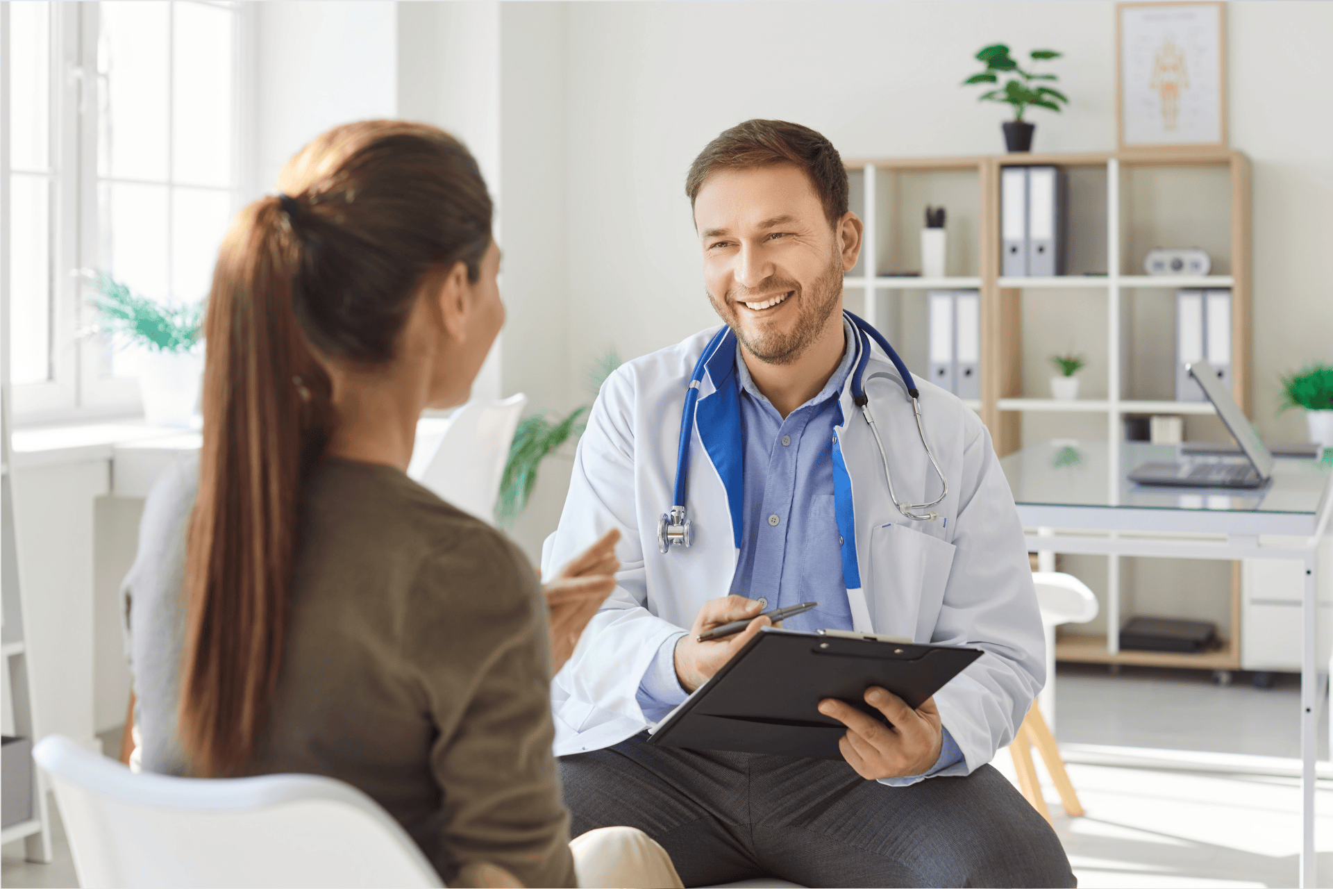 Smiling doctor talking with a patient during a consultation in a bright office.