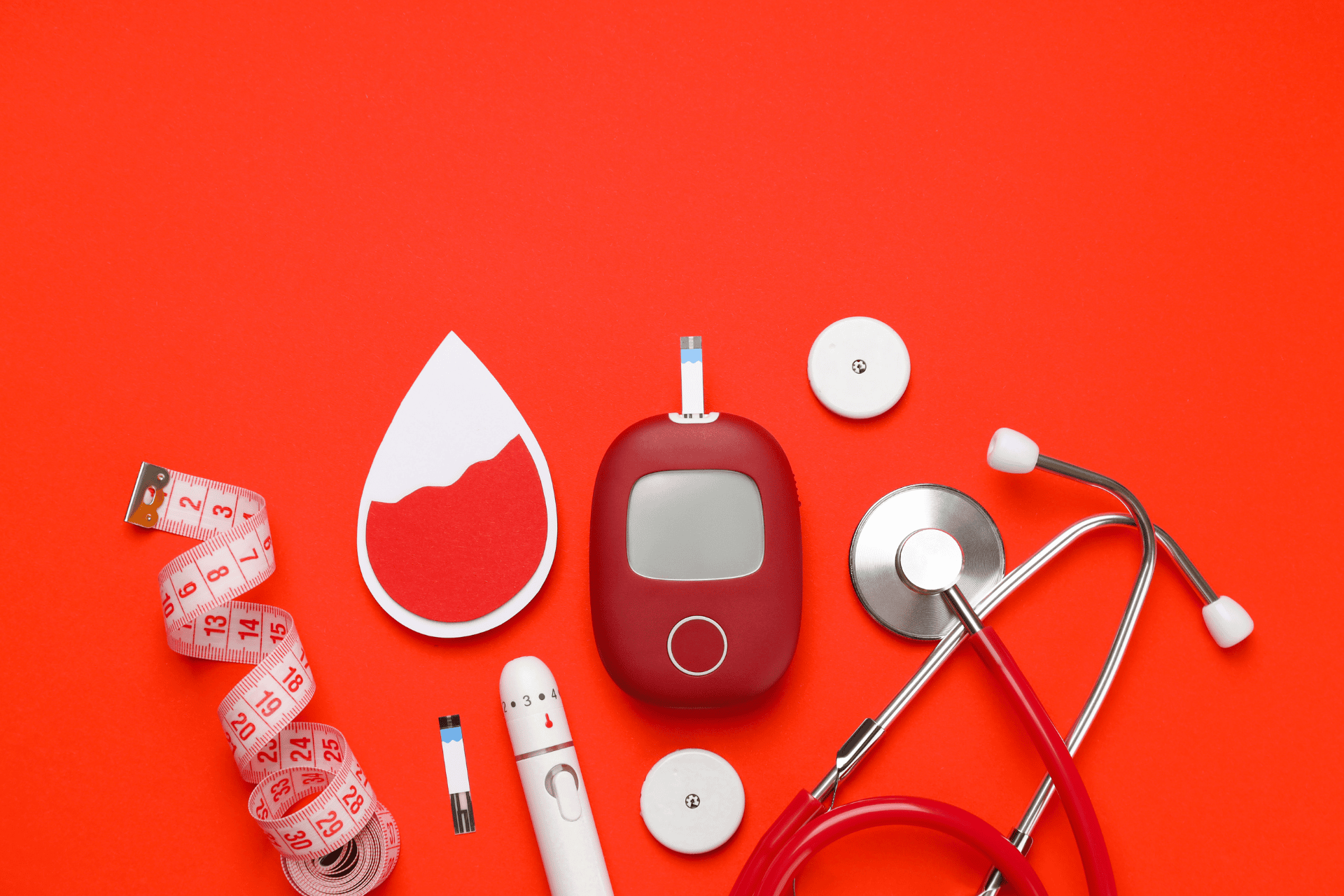 Diabetes care tools, including a glucose meter, test strips, a stethoscope, and measuring tape on a red background.