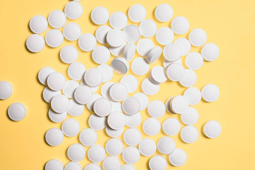Pills on a yellow surface.