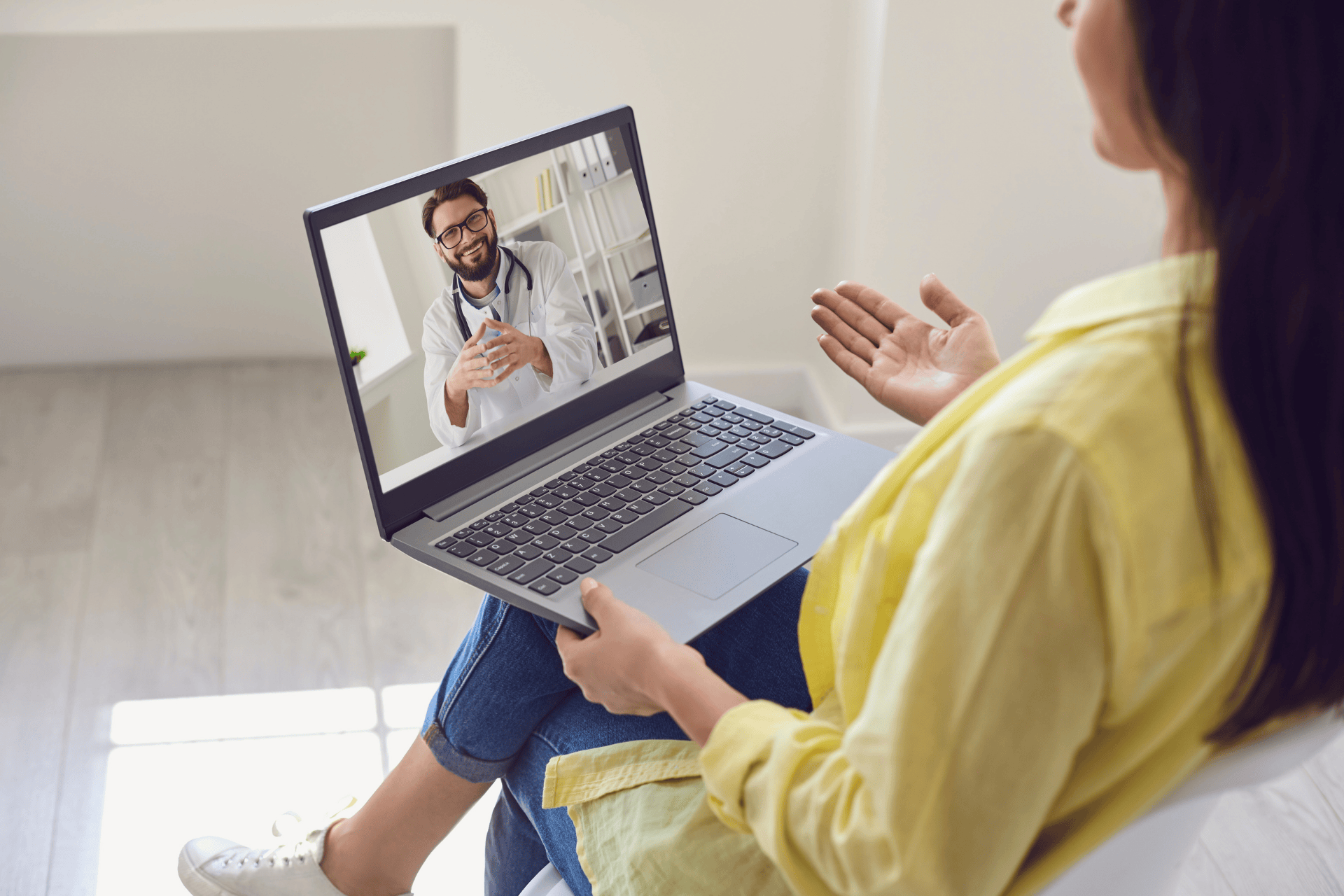 Woman having an online video consultation with a smiling doctor on her laptop