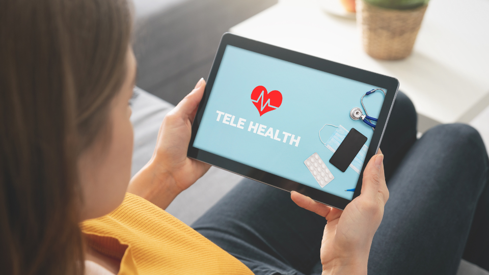 Woman using tablet with screen showing image that says "Tele Health"