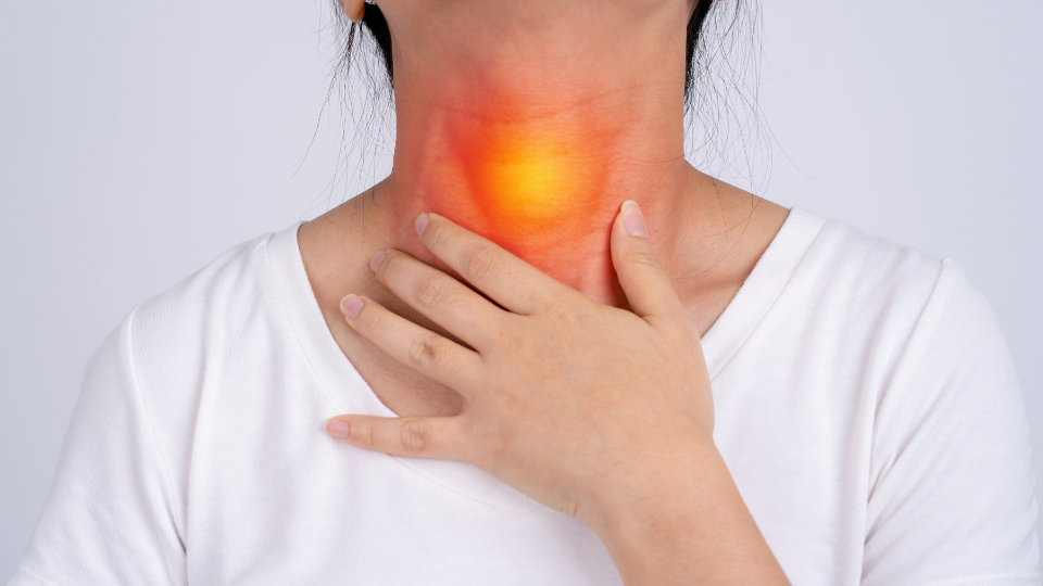 Woman holding her throat with illustration highlighting the area in pain