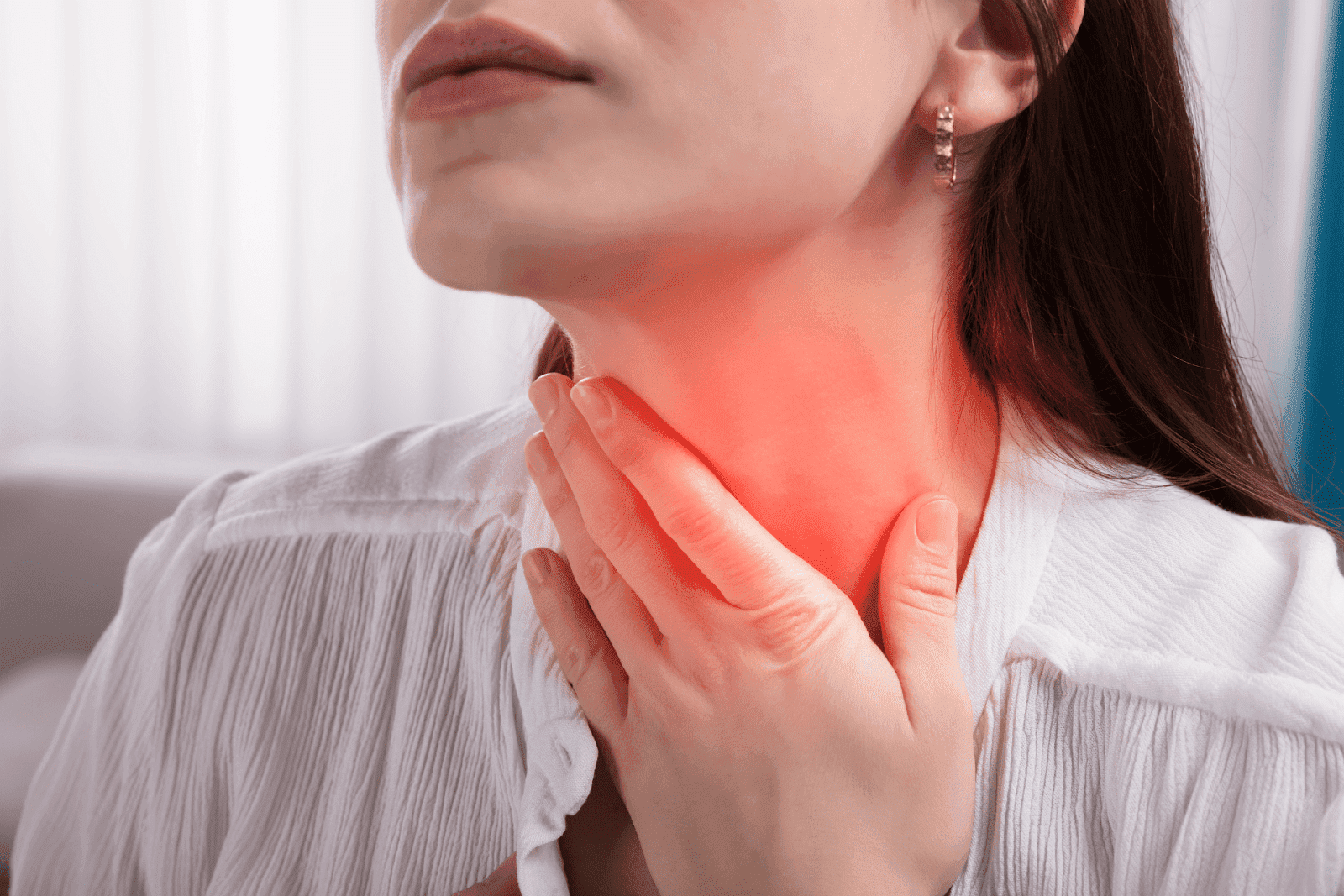 Woman touching her neck with red highlighted area, showing throat pain or inflammation