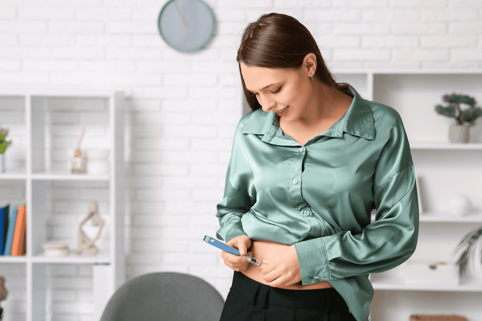 Woman using an insulin pen injection on her abdomen at home.