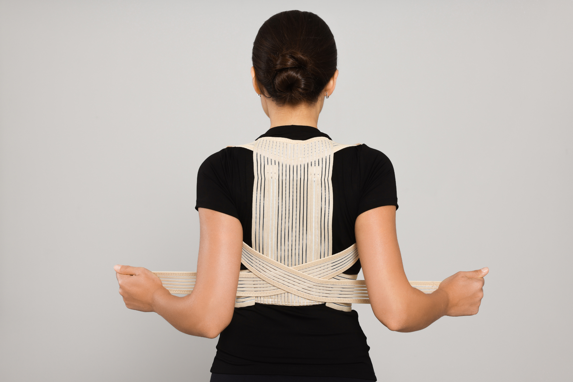 Woman wearing a posture corrector brace to support her upper back