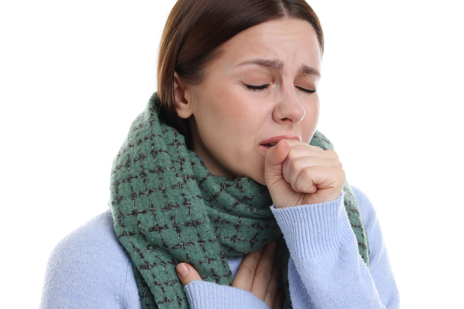 Woman wearing a scarf, coughing into her hand, appearing unwell