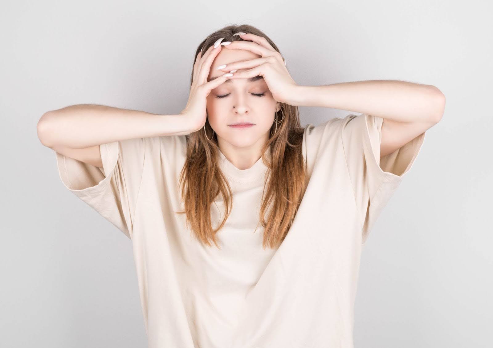 Young woman holding her head out of fatigue