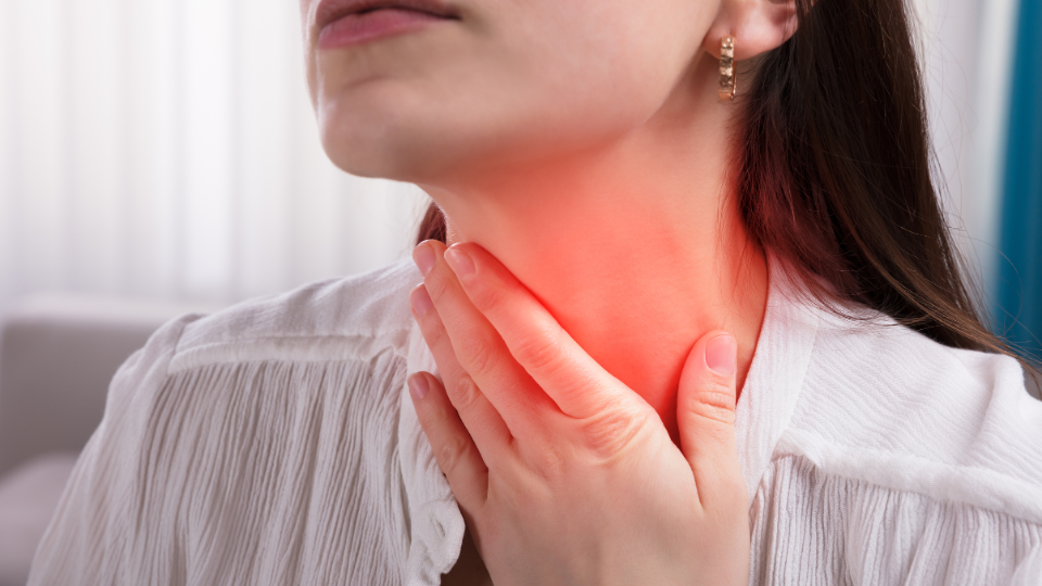 Woman holding throat with illustration showing area of pain