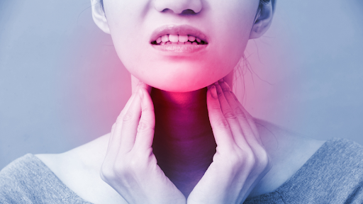Woman touching her throat in discomfort.