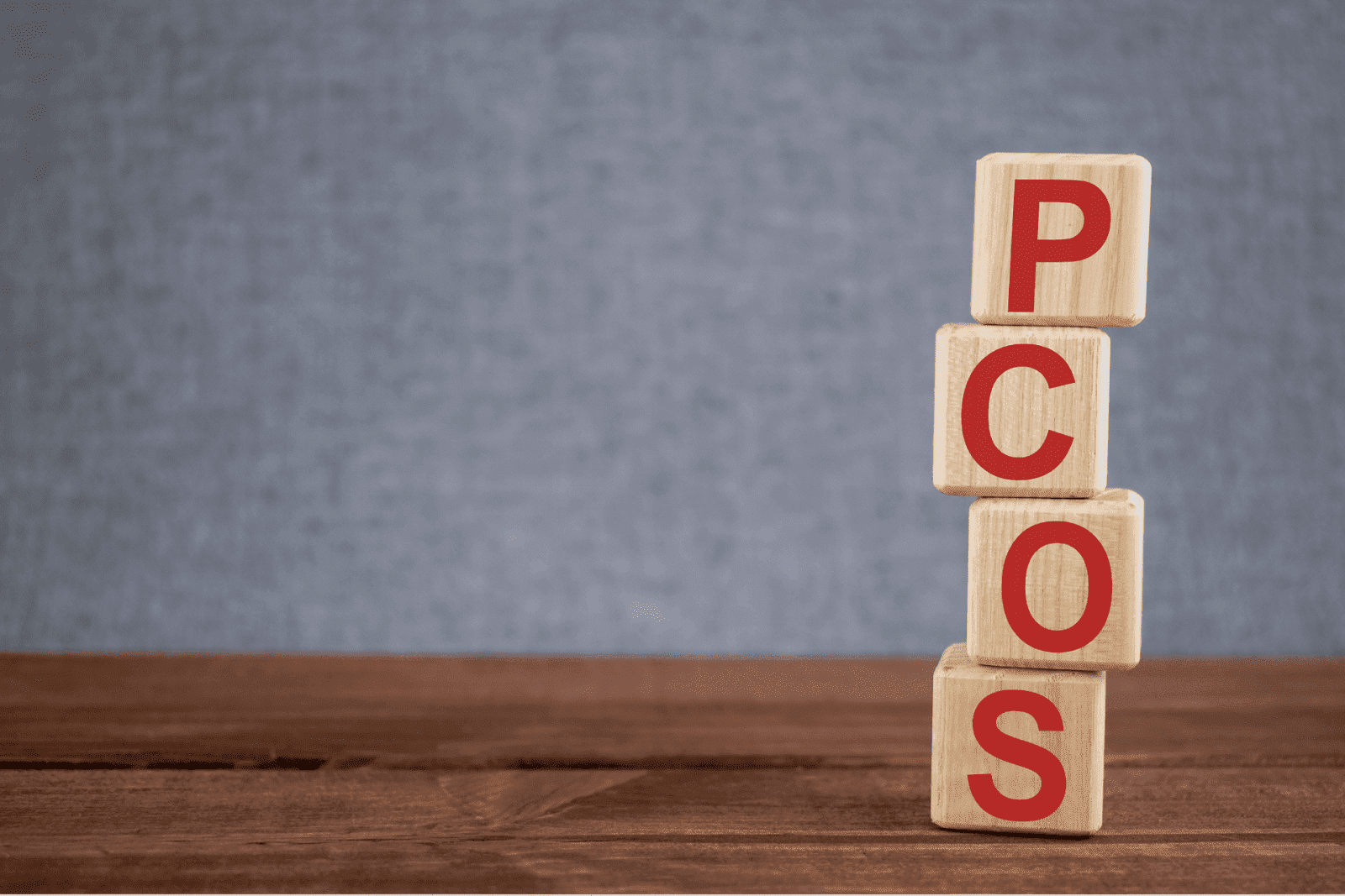 Wooden blocks stacked vertically spelling PCOS.