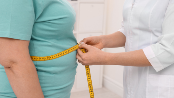 Doctor measuring patients midsection