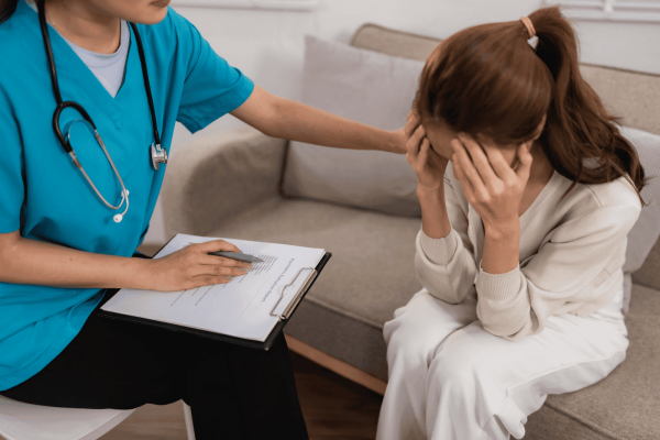 Healthcare worker comforting a distressed woman during a counseling session.