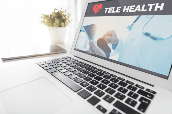 Laptop showing a telehealth service screen with a doctor image and text