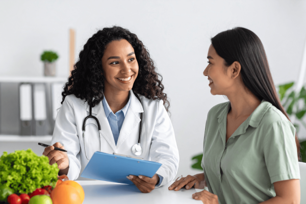 Smiling nutritionist showing a meal plan to a client during a consultation.