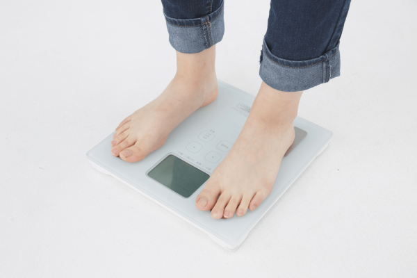 Person standing barefoot on a digital bathroom scale.