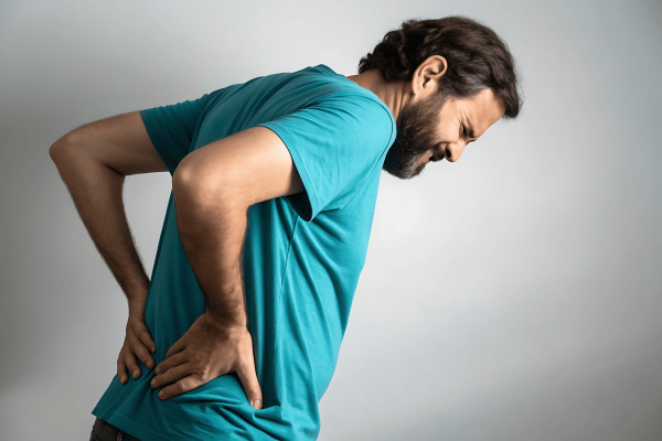 Man holding his lower back in pain, showing discomfort or backache.