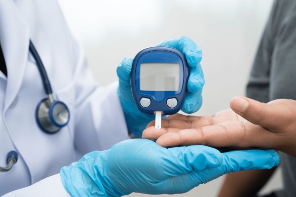 Healthcare worker using a glucose meter to check a patient’s blood sugar.