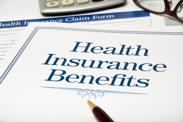 Close-up of health insurance documents and claim forms on a desk.